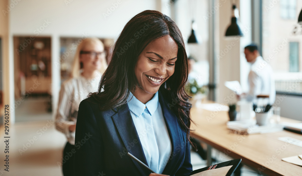 African American businesswoman smiling while walking in an offic