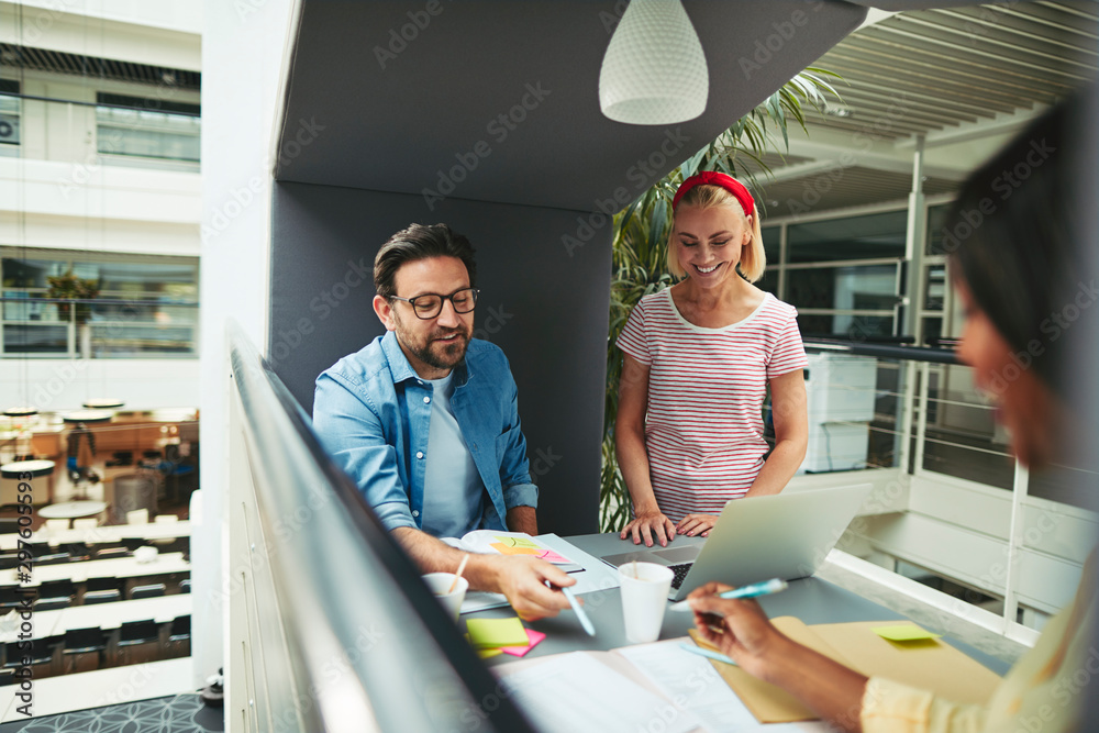 Smiling diverse businesspeople working in an office meeting pod