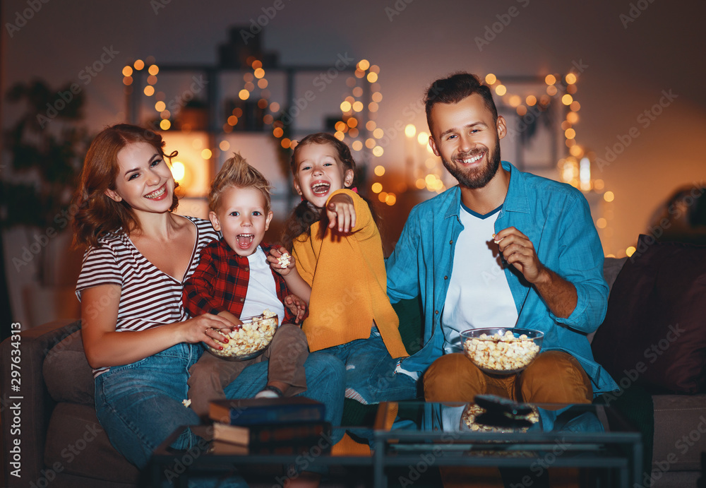 family mother father and children watching projector, TV, movies with popcorn in   evening   at home