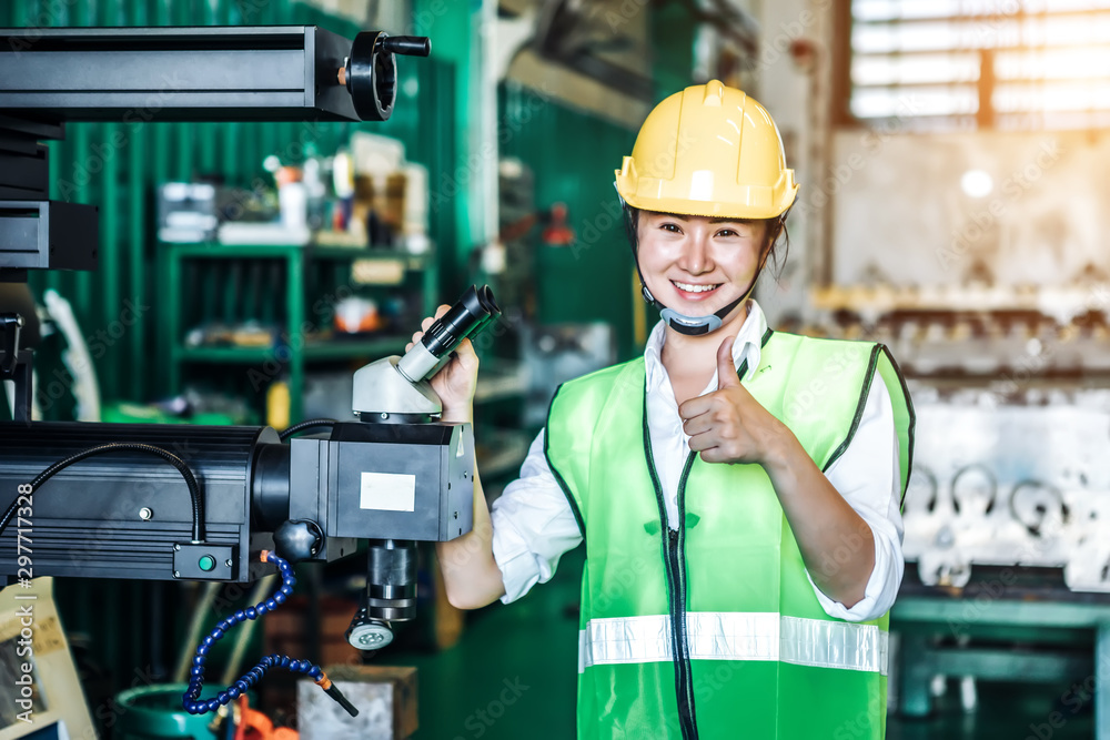 Asian woman is industrial engineer or qc team holding th clipboard while standing in the heavy duty 