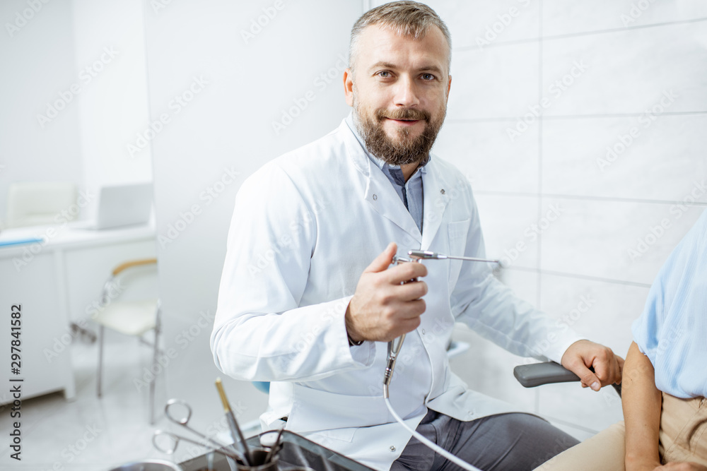 Portrait of a senior otolaryngologist in medical gown with ENT flushing tool in the procedure room