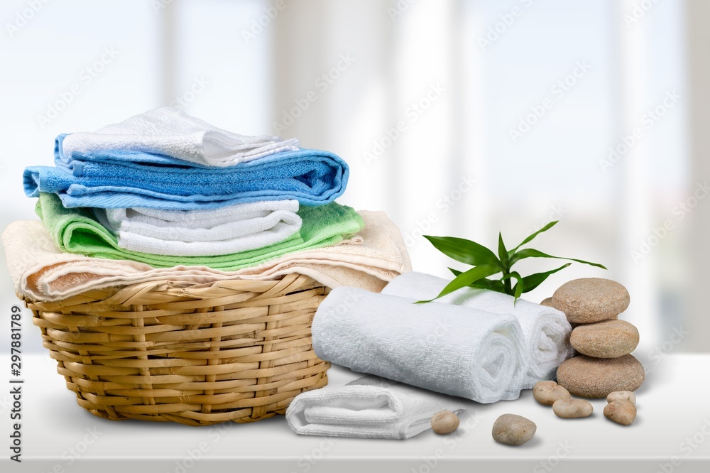 Laundry Basket with colorful towels on background