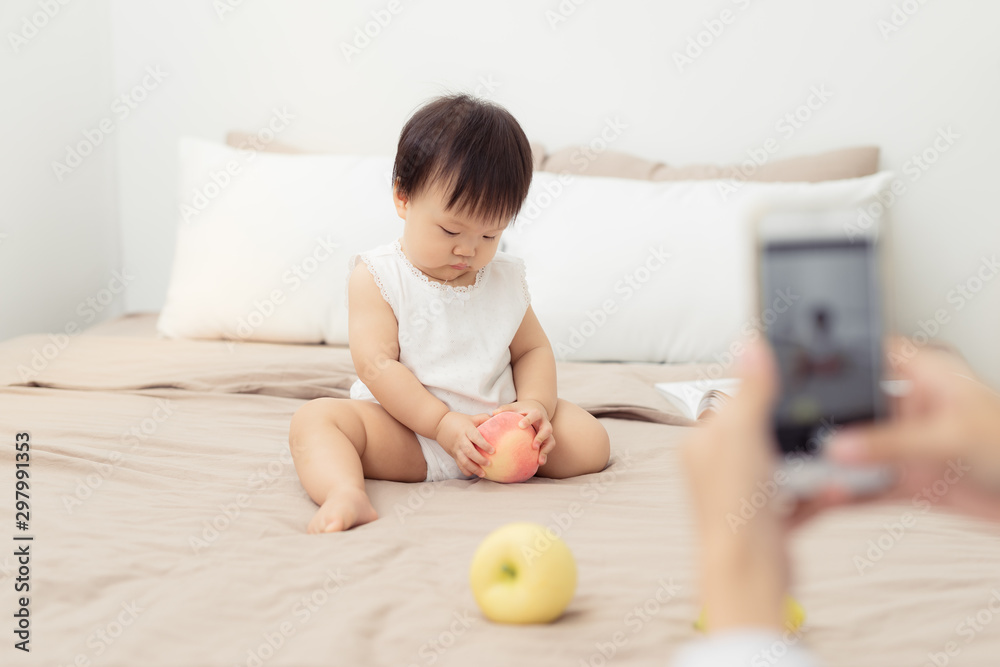 Cute baby playing with toy on bed. Kid playing at home