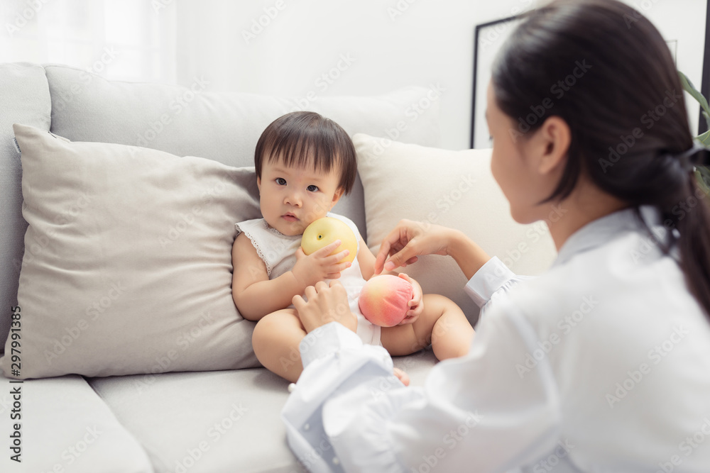 妈妈和她的小女儿在客厅的沙发上玩。