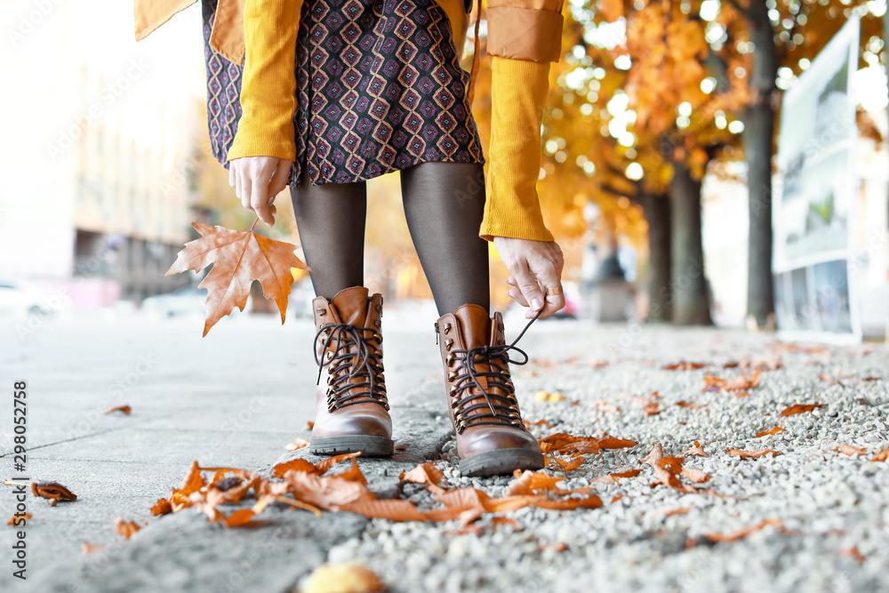 Legs of beautiful young woman in stylish shoes in city on autumn day