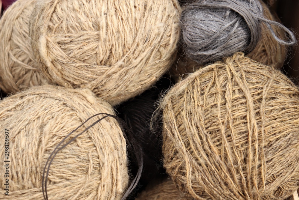 Balls of coarse yarn in gray and beige.