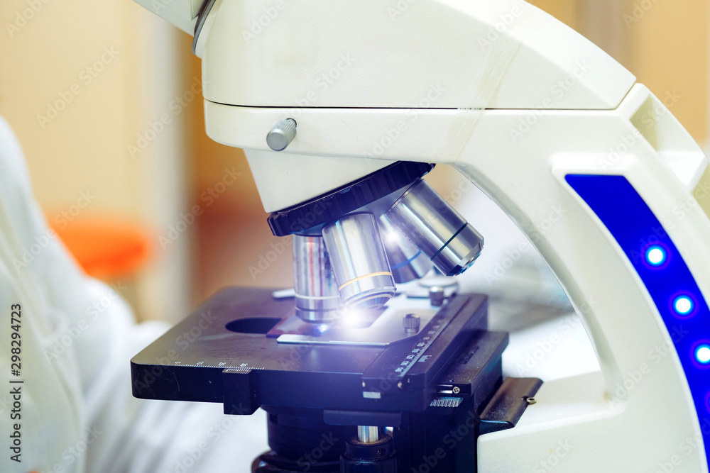 Study under the microscope in the laboratory. Hands in white gloves.