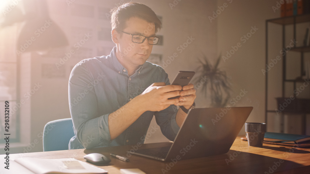 Professional Creative Man Sitting at His Desk in Home Office Studio Working on a Laptop. Man Using S