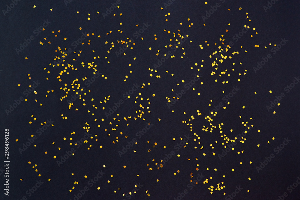 Flat lay composition with golden confetti on a dark background