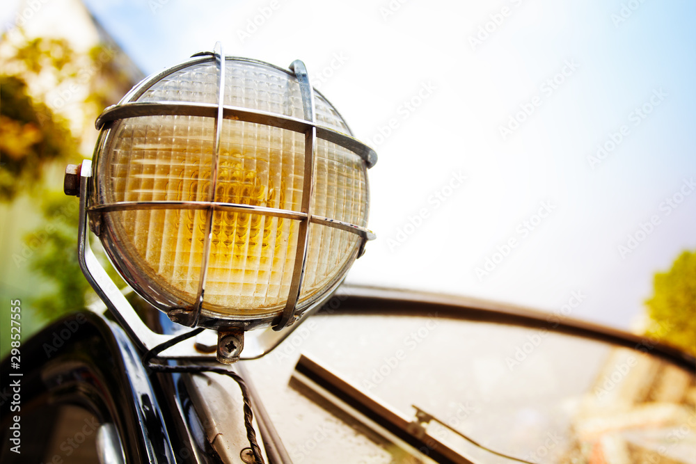 Close up of old head light on rarity black car