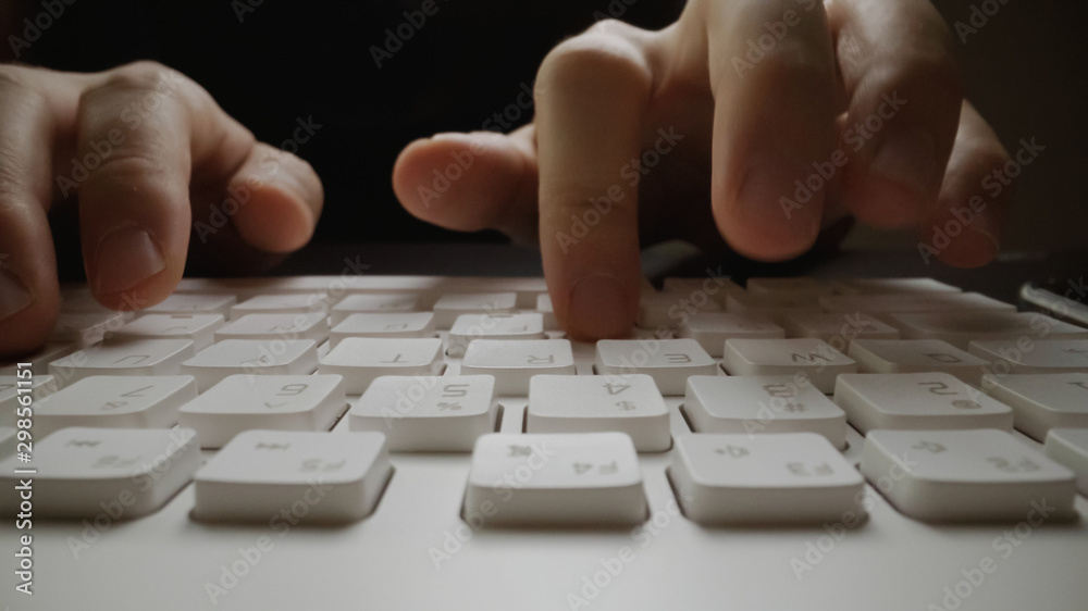 Close-up soft-focus finger typing on keyboard. Man hand using laptop computer in office. Programming