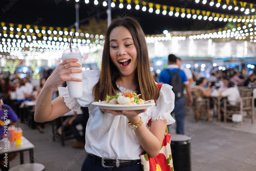 亚洲女游客晚上在泰国吃街头美食