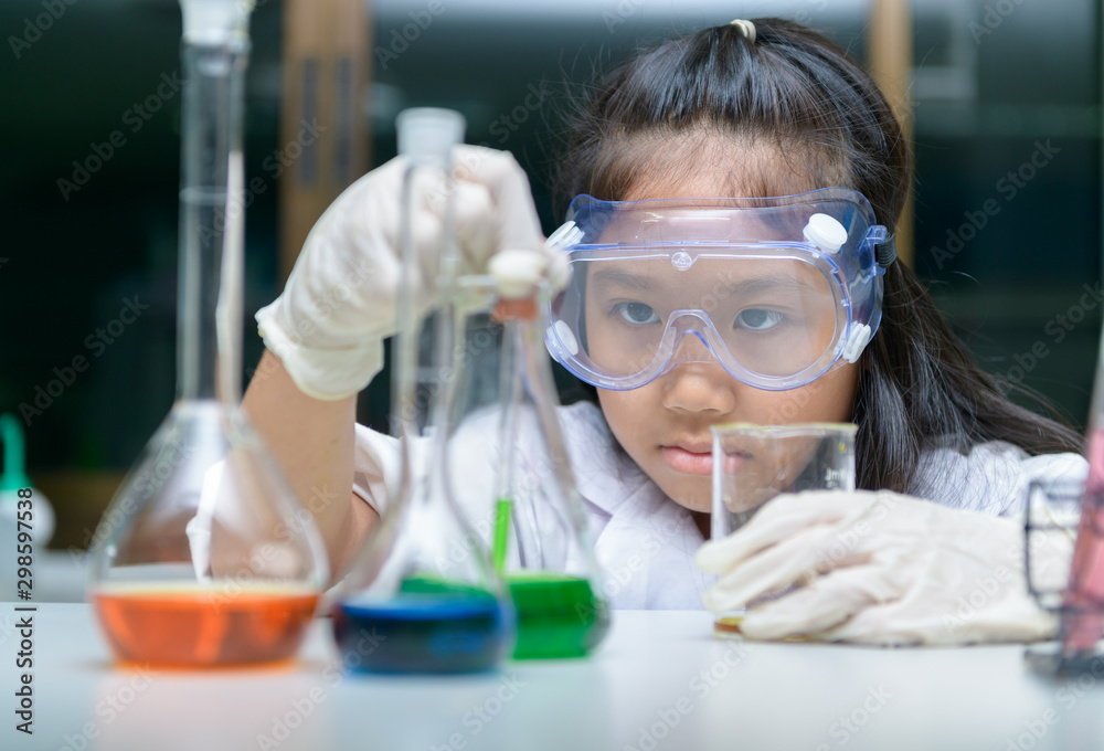  Little girl wearing safty goggle making experiment