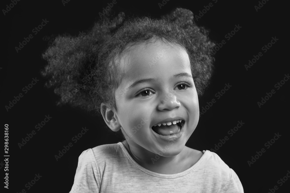 Black and white portrait of little African-American girl on dark background