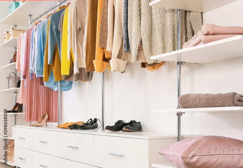 Big wardrobe with clothes in dressing room