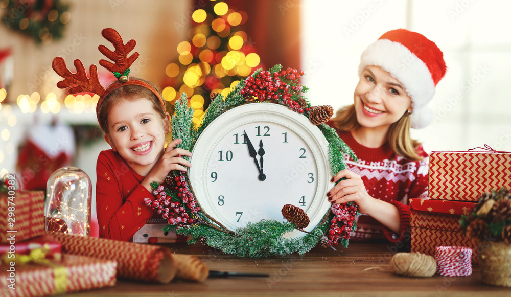 happy family mother and child pack Christmas gifts at home near Christmas tree