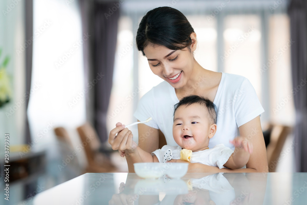 Asian mother feed soup to her baby