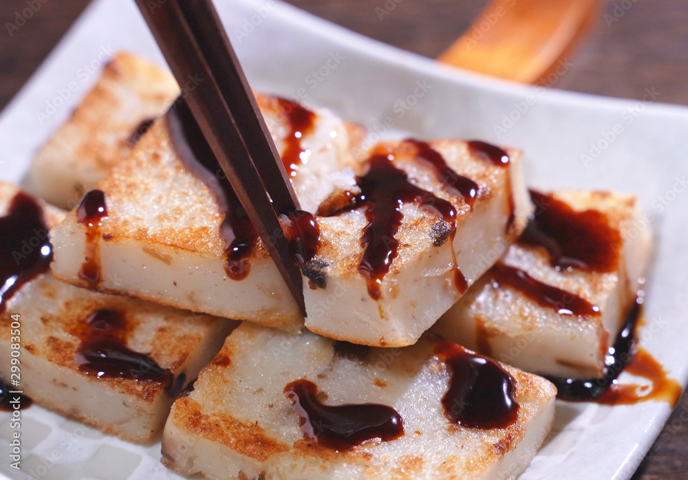 在即食美味萝卜饼上浇黑酱油，中国传统土菜萝卜