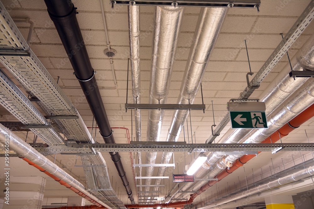 Water pipes and cable trays run under ceiling of a building