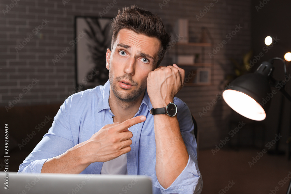 Tired man trying to meet deadline in office