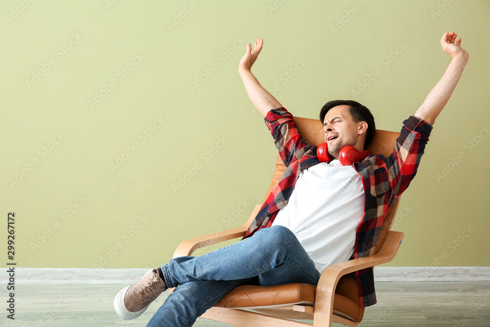 Handsome man relaxing in armchair at home