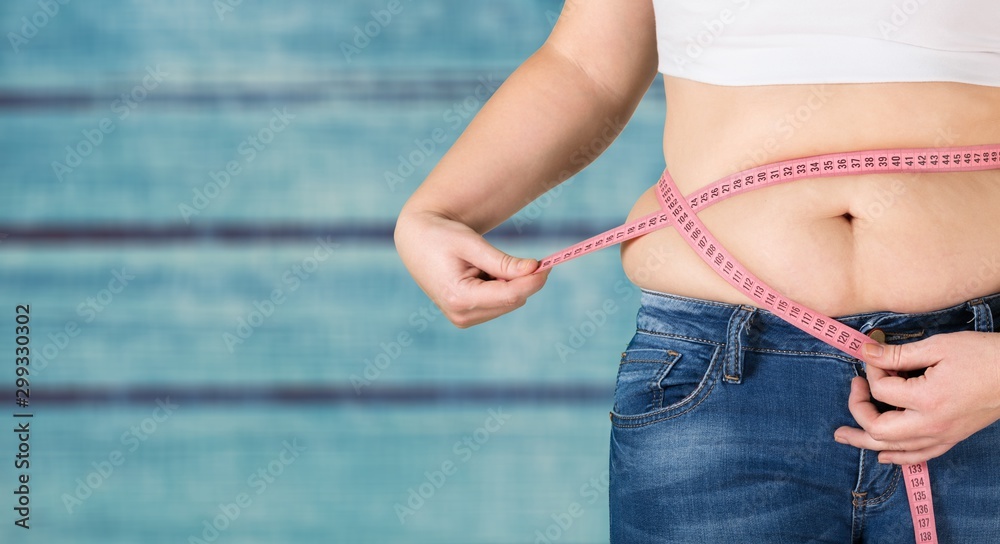 Close-up female figure with measuring tape on grey background