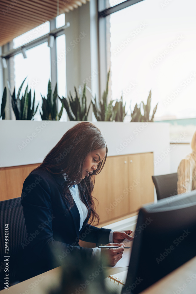 Focused young African American businesswoman reading paperwork a