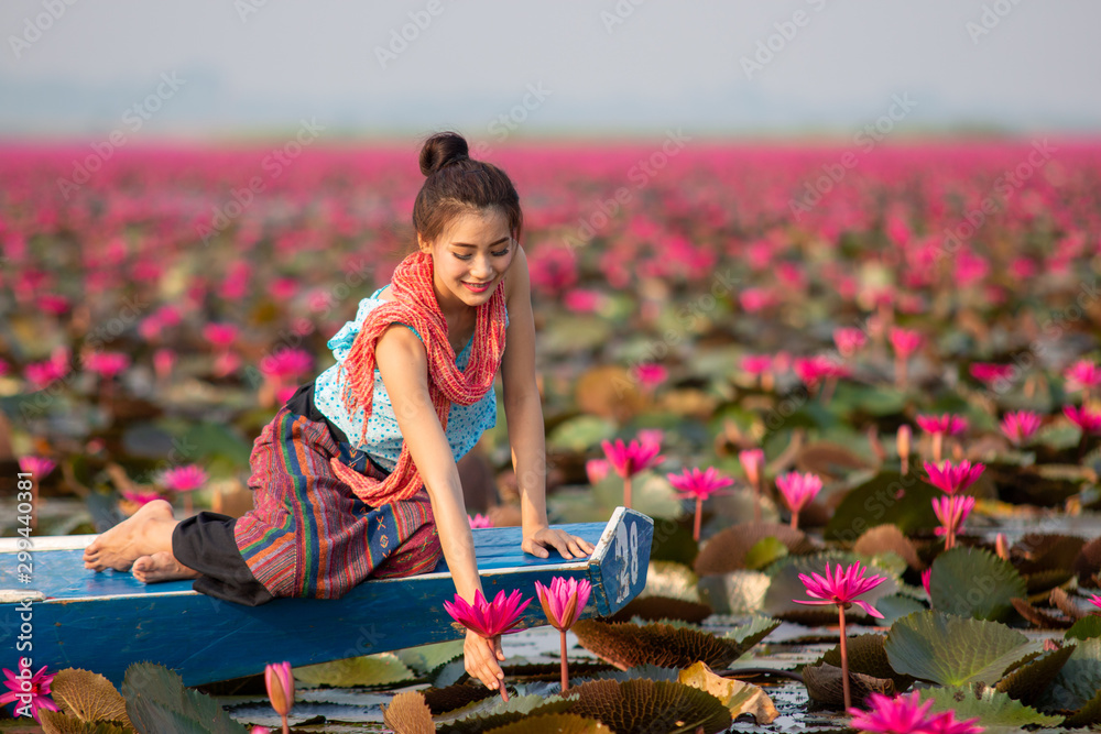 Woman on a boat in the lake red Lotus,Beautiful women in Lotus Gardens.