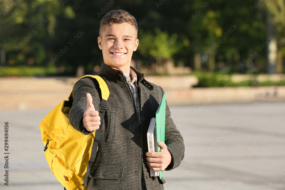 青少年男学生在户外竖起大拇指的肖像