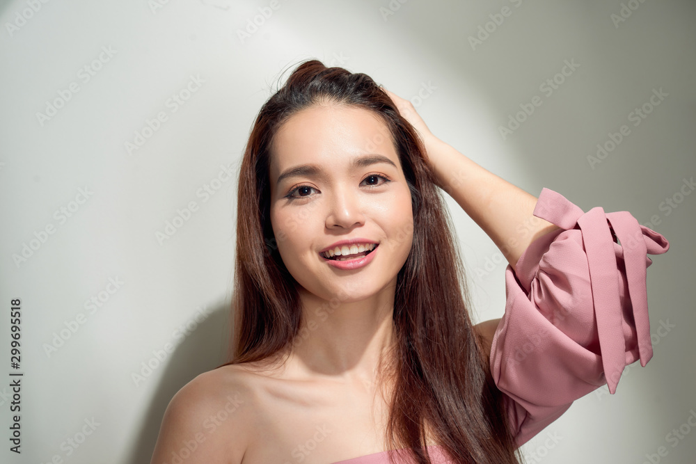 Spectacular asian young woman playing with her hair. Indoor photo of wonderful female model isolated