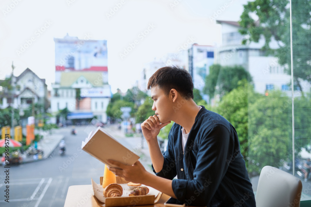 Man reading a book in a coffee shop