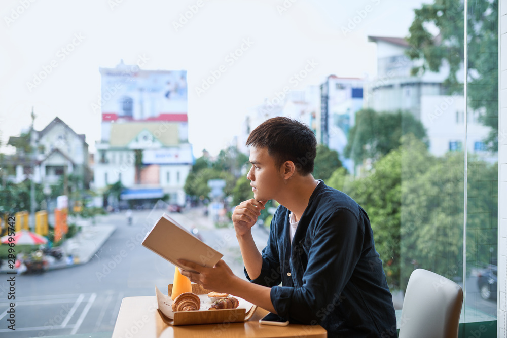 Man reading a book in a coffee shop