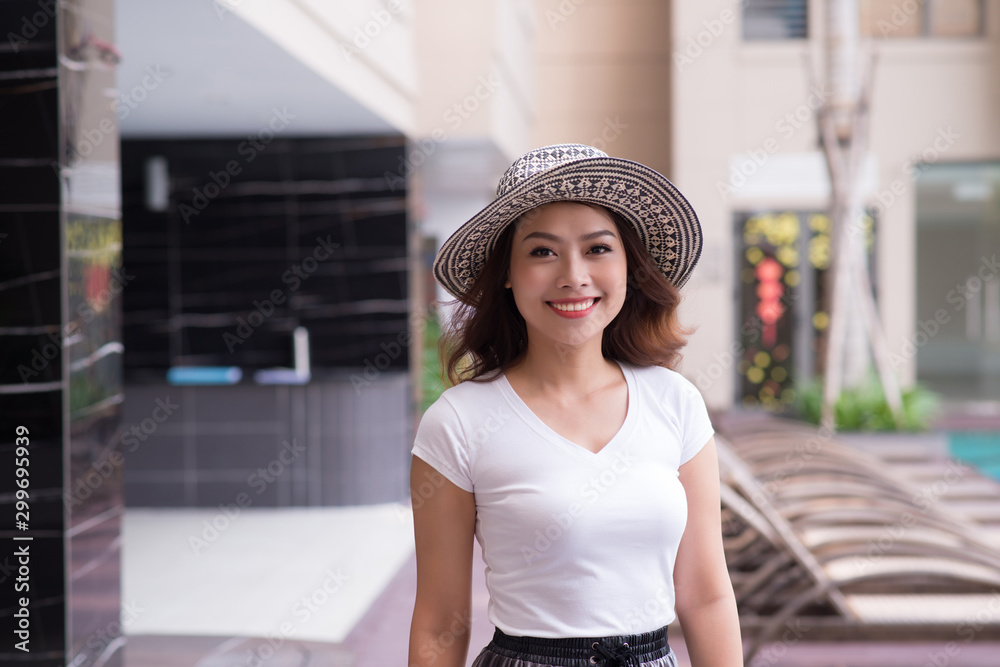 Isolated portrait of smiling  Asian woman wearing big summer hat