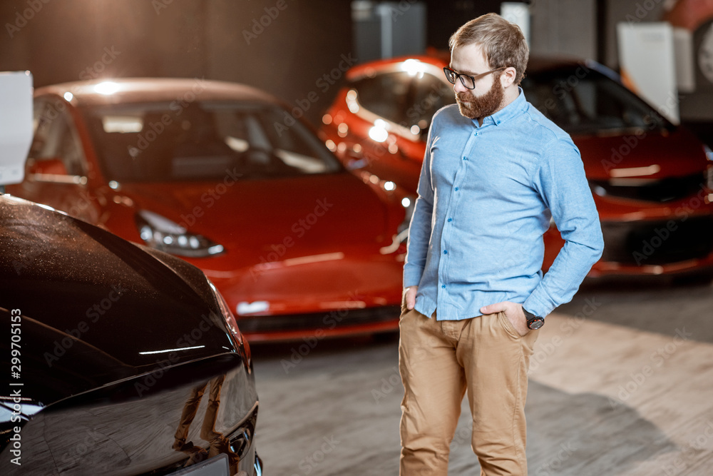 Man choosing electric car at the showroom