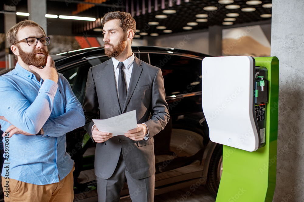 Customer with a seller at the showroom with car charges