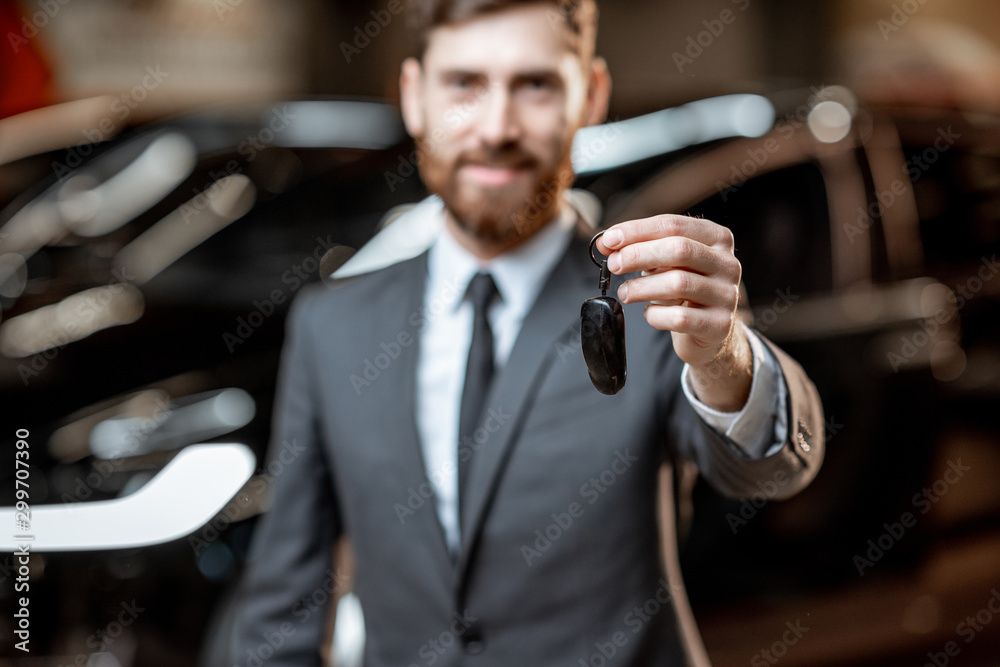 Salesman with key at the car dealership