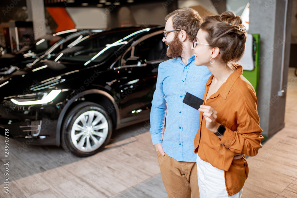 Couple buying electric car at the dealership