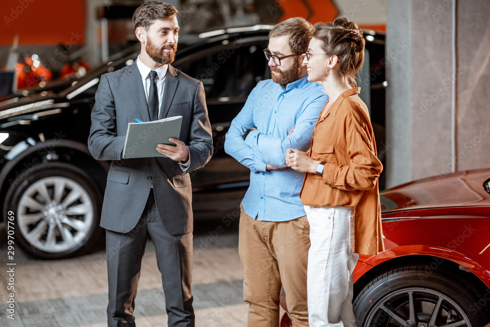 Couple with sales manager in the car dealership