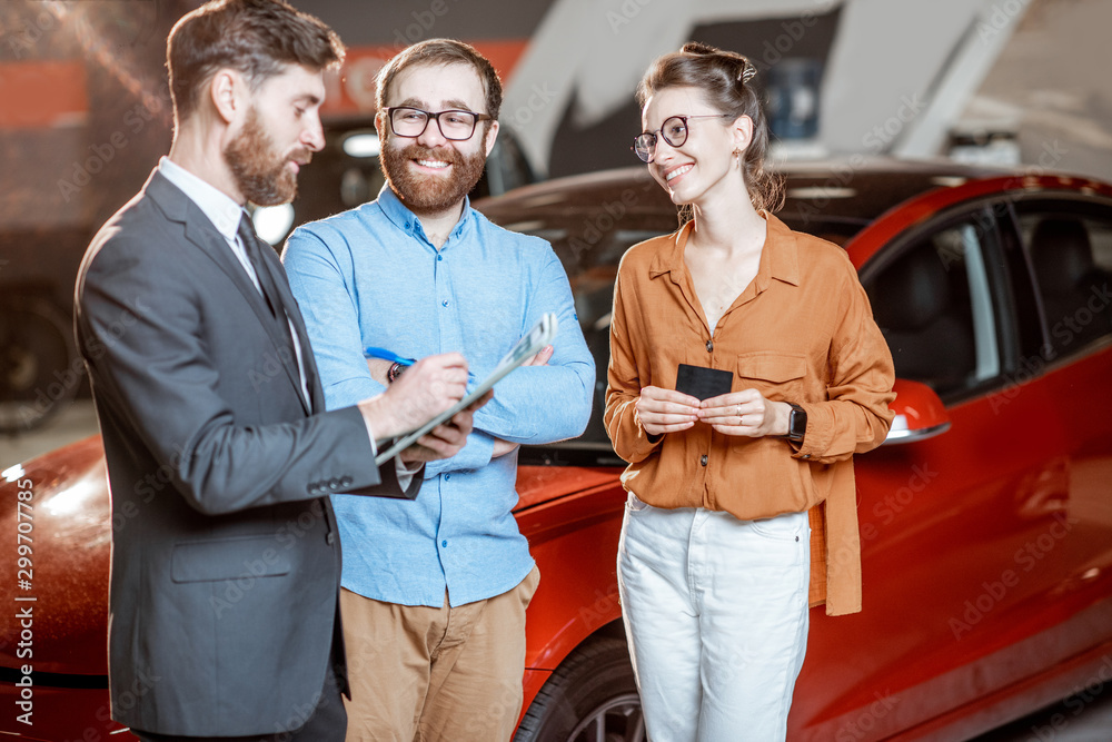 Couple with sales manager in the car dealership