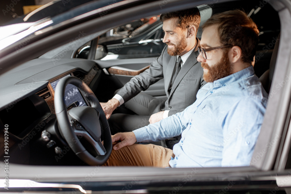 Sales manager with a client looking at the vehicle interior