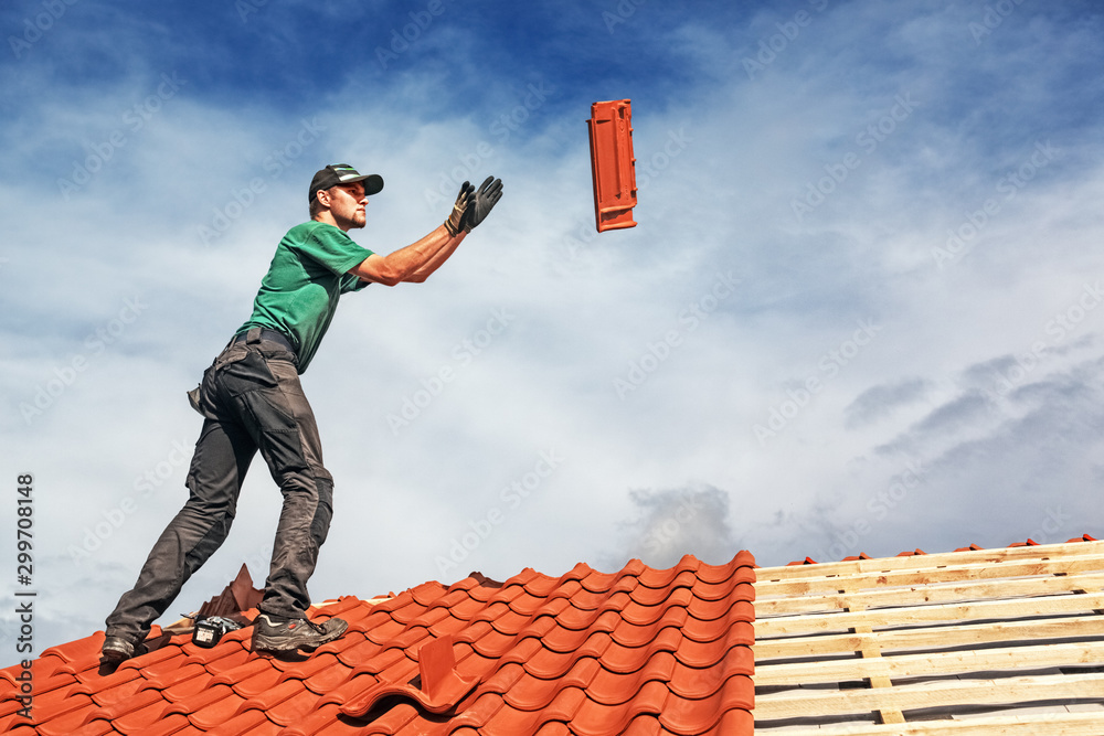 Roofer at work, installing clay roof tiles, Germany