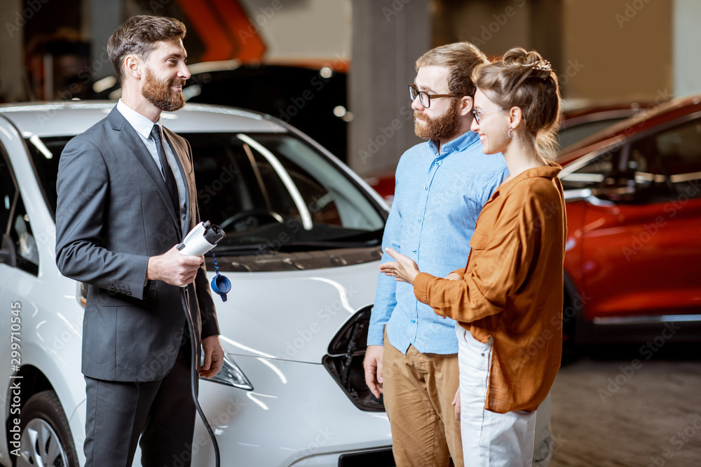 Sales manager selling electric car to a young couple