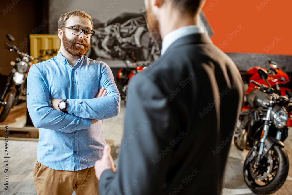 Sales consultant with a client in the showroom with motorcycles