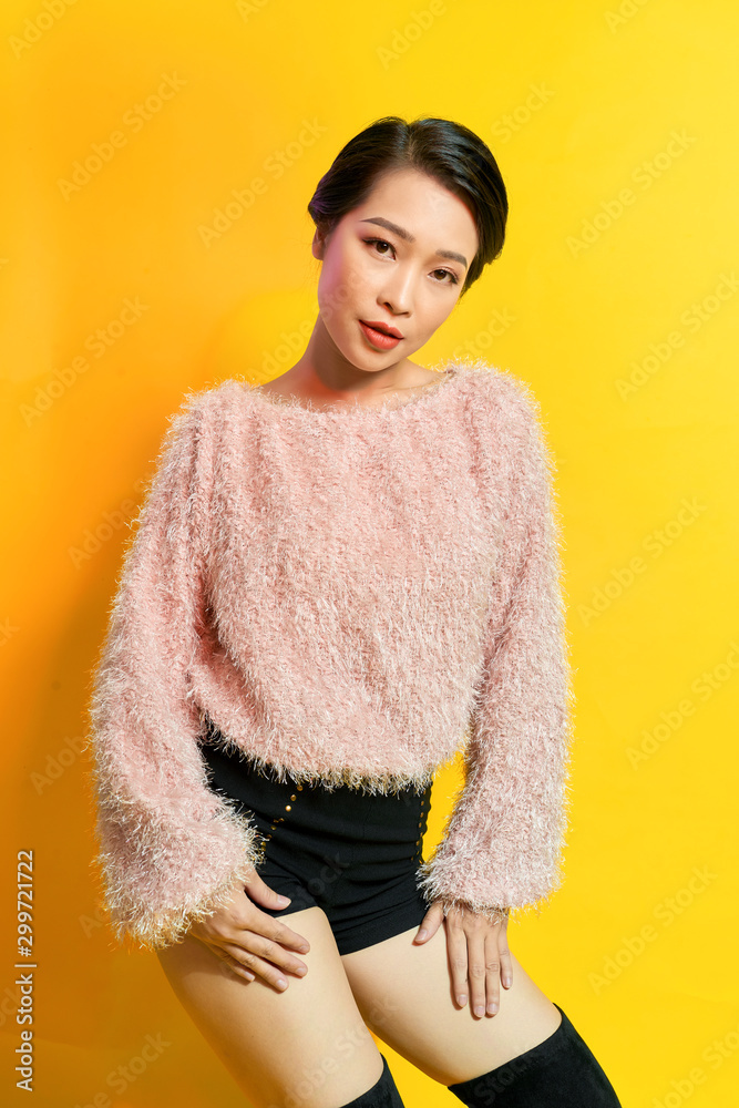 Adorable woman expressing true positive emotions during photoshoot in pink fur coat. Indoor portrait