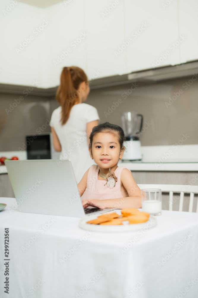 Happy Asian family are eating breakfast and see digital tablet in the kitchen at home. Healthy food 