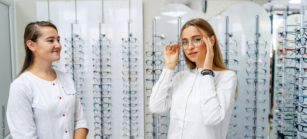 Optician正在帮助女性客户选择光学眼镜。眼部保健概念。spect的原始数据