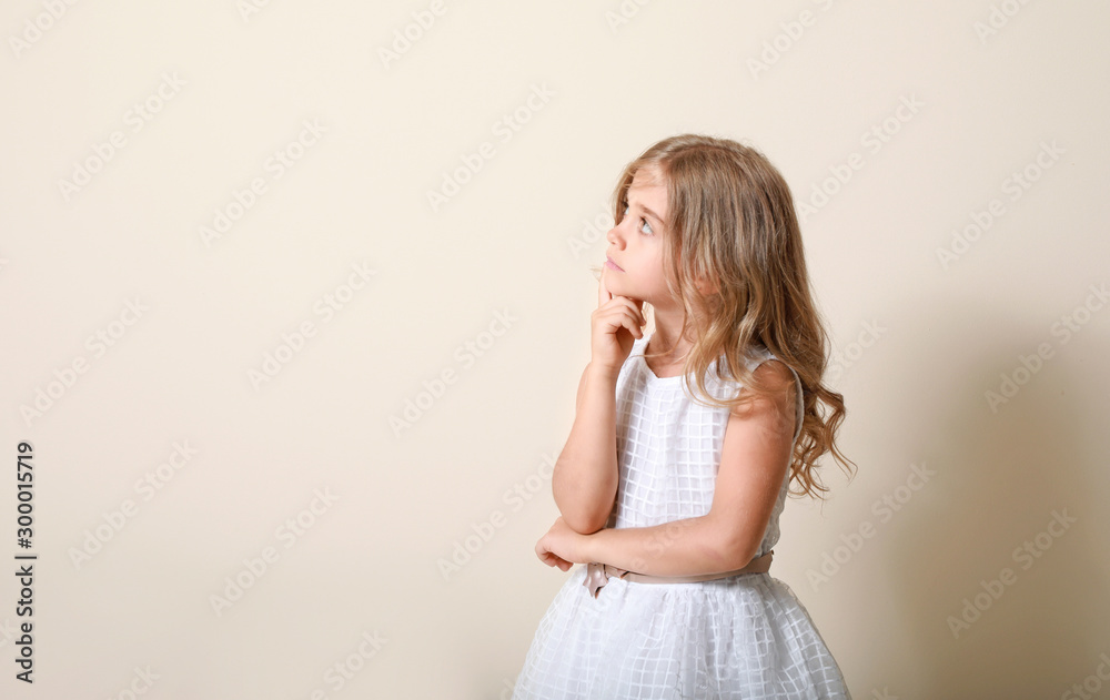 Thinking little girl on light background