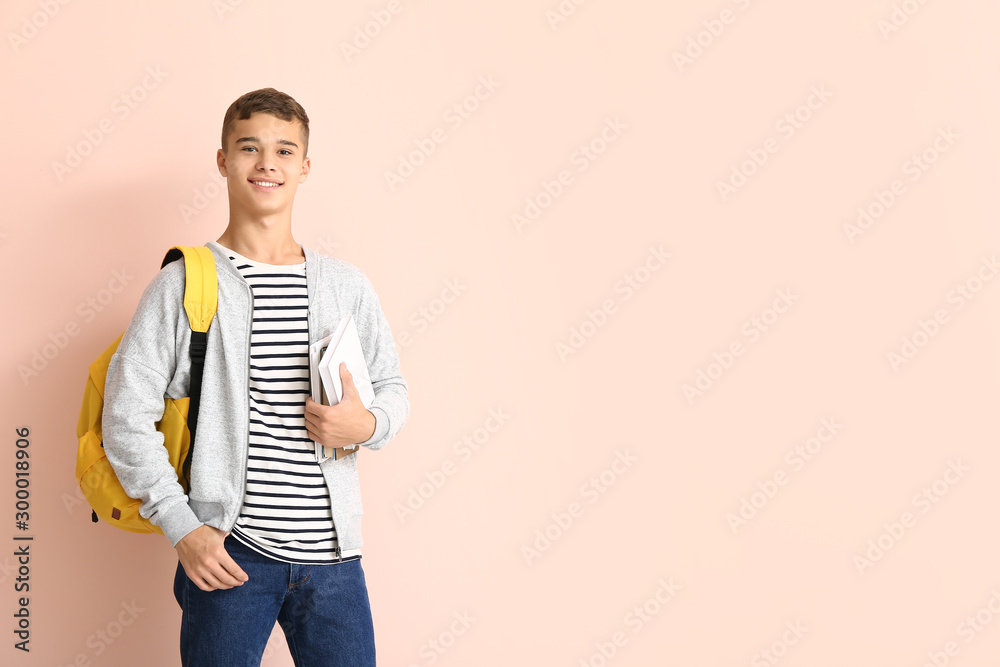 Portrait of teenage schoolboy on color background