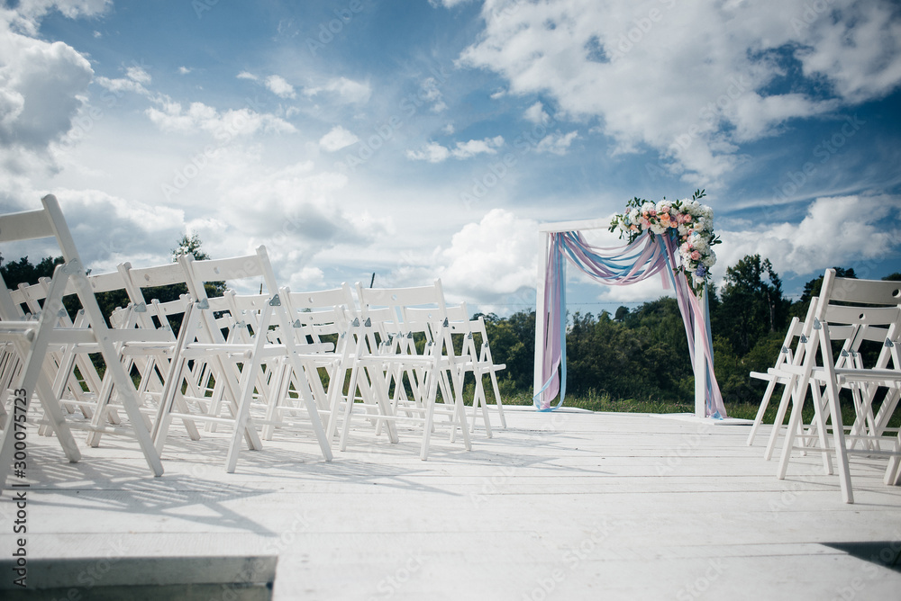 chairs and arch for a wedding ceremony on a sunny bright day