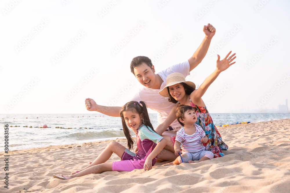 Asian big family enjoy relaxing time together on the beach. Father mother and children raising hands